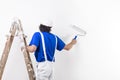 Painter man at work climbing a vintage wooden ladder and paintin Royalty Free Stock Photo