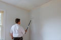 painter man at work with a paint roller and bucket, wall painting concept Royalty Free Stock Photo