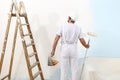 Painter man at work with a paint roller and color samples Royalty Free Stock Photo