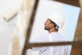 Painter man at work with a paint roller, wall painting Royalty Free Stock Photo