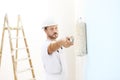 Painter man at work with a paint roller, wall painting Royalty Free Stock Photo