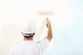 Painter man at work with a paint roller, wall painting Royalty Free Stock Photo