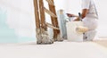 Painter man at work with a roller, bucket and scale, from below view, copy space