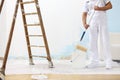 Painter man at work takes the color with paint roller from the b Royalty Free Stock Photo