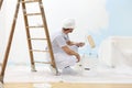 Painter man at work takes the color with paint roller from the b Royalty Free Stock Photo