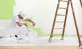 Painter man at work takes the color with roller paint brush from Royalty Free Stock Photo