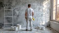Painter With Paint Roller Contemplating Grey Wall, Home Renovation And Interior Design Project Royalty Free Stock Photo
