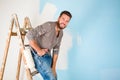 Painter in paint splattered shirt painting a wall Royalty Free Stock Photo