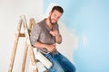 Painter in paint splattered shirt painting a wall Royalty Free Stock Photo