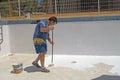 Painter painting the bottom of a swimming pool