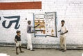 Painter painting a fridge at a white brick wall