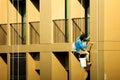 Painter painting on high rise building