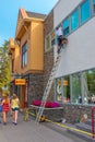 Painter painting window trim in Banff Business District