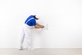 Painter with paintroller on white wall