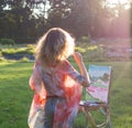 The painter paints oil paintings in the garden at sunset Royalty Free Stock Photo