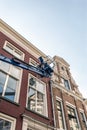 Painter in platform maintaining old building. Deventer, Overijssel, Netherlands. Royalty Free Stock Photo