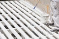 Painter Rolling White Paint Onto Top of Patio Cover Royalty Free Stock Photo