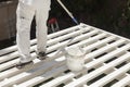 Painter Rolling White Paint Onto Top of Patio Cover Royalty Free Stock Photo