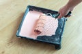 The painter`s hand dips the roller into a plastic tray with pink paint Royalty Free Stock Photo