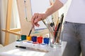 Painter`s hand holds brush on the background of easel Royalty Free Stock Photo