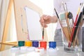 Painter`s hand holds brush on the background of easel Royalty Free Stock Photo