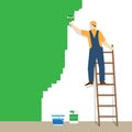 Painter standing on staircase paints the wall