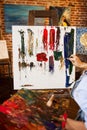 Painter at the studio creating abstract picture on canvas using oil paintings and palette knife. Young female artist Royalty Free Stock Photo