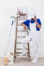 Painter in white dungarees and painting tools