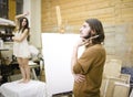 Painter at work with model muse in studio waiting inspiration Royalty Free Stock Photo