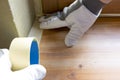 Painter worker protecting window sills with masking tape before painting at home improvement work Royalty Free Stock Photo