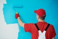 Painter worker with roller painting ceiling surface into white Royalty Free Stock Photo