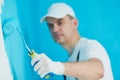 Painter worker with roller painting wall surface Royalty Free Stock Photo