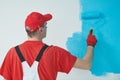 Painter worker with roller painting wall surface Royalty Free Stock Photo
