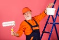 Painter working at construction site. senior man use roller on ladder. work in apartment. Craftsman With Paint Roller Royalty Free Stock Photo