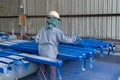 Painter is working to painting color top coat on steel structure with spray gun, at industrial factory