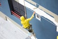 Painters hanging on roll, painting color on building wall Royalty Free Stock Photo