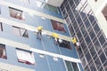 Painters hanging on roll, painting color on building wall Royalty Free Stock Photo