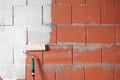 Painting a brick wall white with a paint roller on a construction site, background concept for renovation, building and home, copy Royalty Free Stock Photo