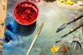 painting brushes, palette and red poster paint on wooden table