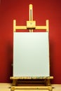 Painting easel with white canvas for text in dramatic light Royalty Free Stock Photo