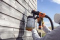 Painting fence or garden shed with a paint sprayer Royalty Free Stock Photo