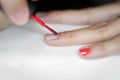 Painting fingers with pink coral nails on white background