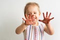 Painting is fun for kids - happy girl plays t with dirty hands. Baby girl shows her hands in the colorful painting Royalty Free Stock Photo