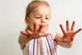 Painting is fun for kids - happy girl plays t with dirty hands. Baby girl shows her hands in the colorful painting Royalty Free Stock Photo