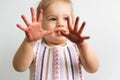 Painting is fun for kids - happy girl plays t with dirty hands. Baby girl shows her hands in the colorful painting Royalty Free Stock Photo