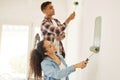 Painting, love and renovation with a couple doing DIY in a room for improvement and remodel of their home. Young man and Royalty Free Stock Photo