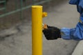 Painting a metal post with yellow paint. Parking bollard painting Royalty Free Stock Photo