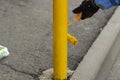 Painting a metal post with yellow paint. Parking bollard painting Royalty Free Stock Photo