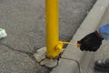 Painting a metal post with yellow paint. Parking bollard painting Royalty Free Stock Photo