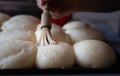 Painting milk on uncooked Bread rolls. ,making bread rolls at home Royalty Free Stock Photo